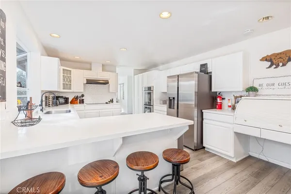 a kitchen with kitchen island a stove a table and chairs