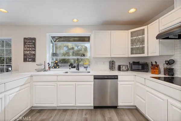 a kitchen with white cabinets and white appliances