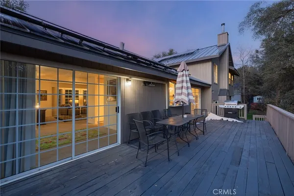 a view of a deck with table and chairs with wooden floor and fence