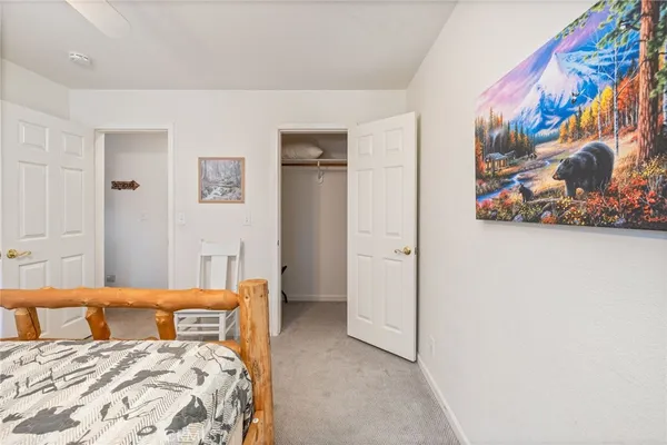 a bedroom with a bed and painting on the wall