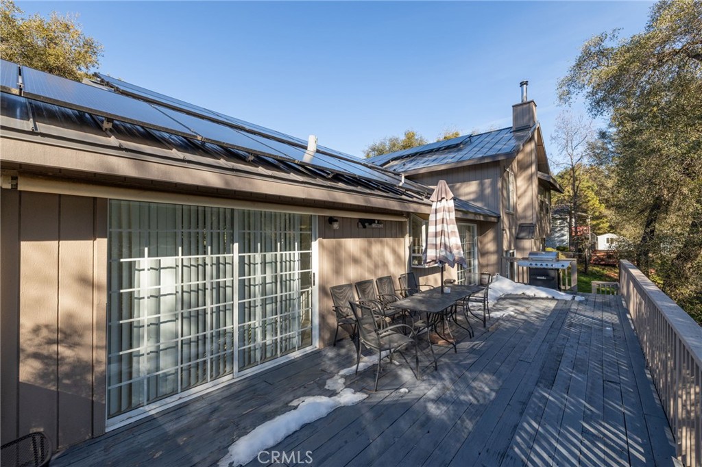 39301 Moonray Lane Oakhurst, CA 93644 - Photo 46 of 55 a view of a patio with table and chairs with wooden floor and fence
