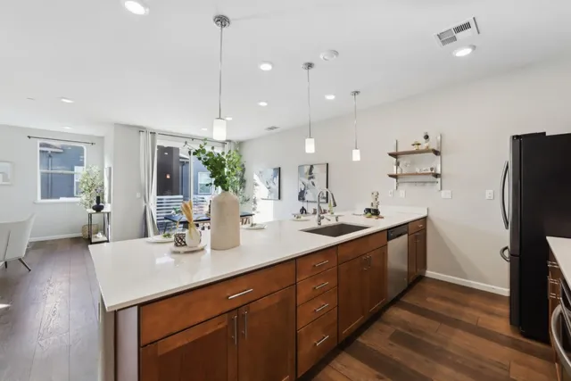 a kitchen with stainless steel appliances kitchen island a refrigerator sink and stove