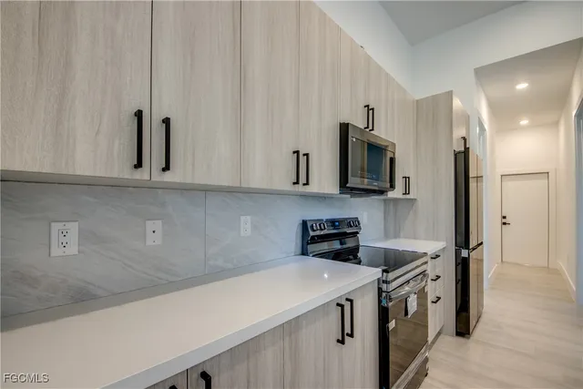 a kitchen with stainless steel appliances a sink a stove and a refrigerator