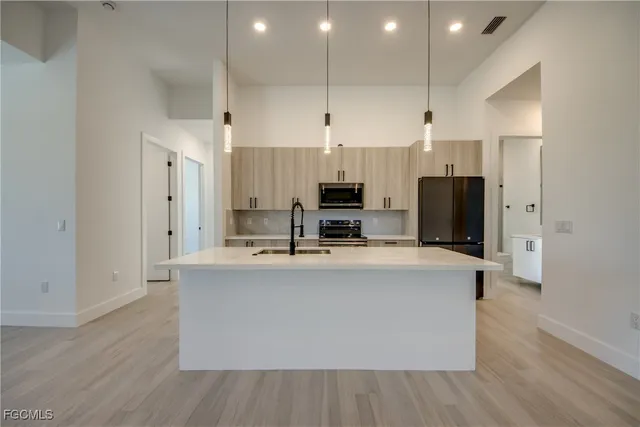 a view of kitchen with stainless steel appliances a refrigerator and a stove top oven