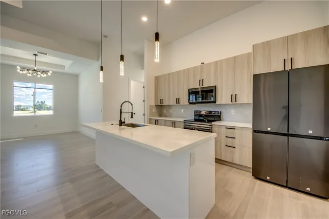 a kitchen with stainless steel appliances a refrigerator stove microwave and sink