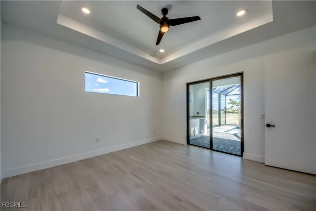 an empty room with wooden floor and ceiling fan
