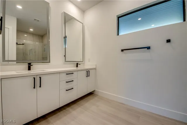 a bathroom with a double vanity sink and mirror