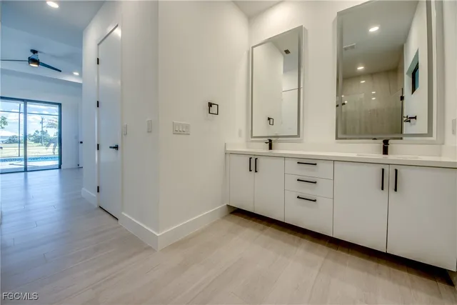 a spacious bathroom with a double vanity sink a mirror and a shower