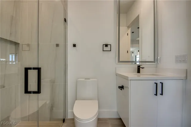 a bathroom with a toilet sink a mirror and shower