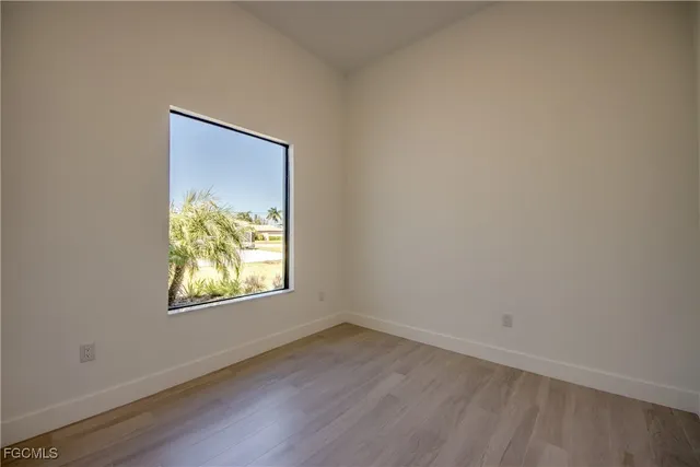 an empty room with window and wooden floor