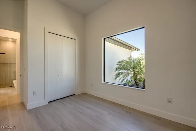 an empty room with window and hallway