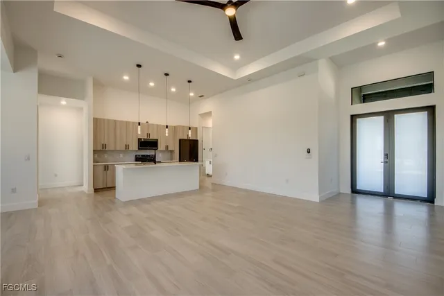 a view of kitchen with stainless steel appliances kitchen island wooden floor and living room view