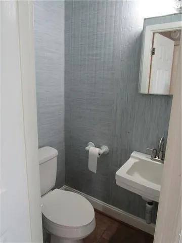 a bathroom with a toilet a sink and mirror
