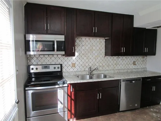 a kitchen with sink cabinets and stainless steel appliances