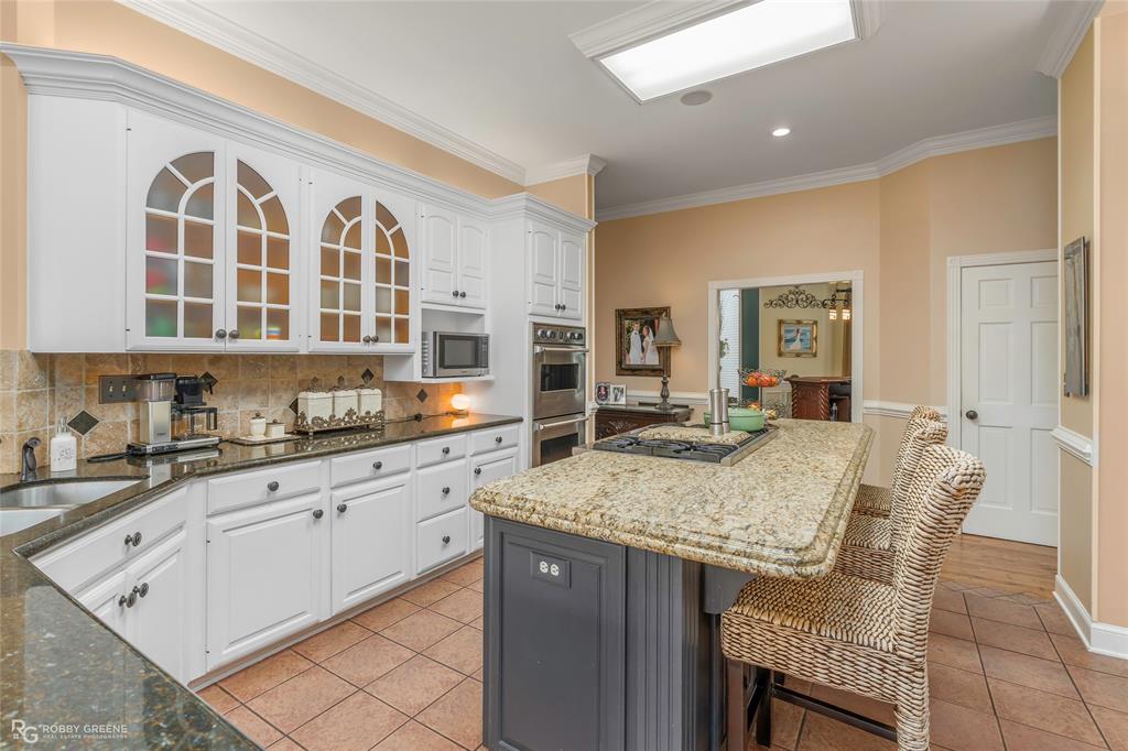 195 Tanglewood Road Homer, LA 71040 - Photo 7 of 37 a kitchen with granite countertop kitchen island cabinets and refrigerator