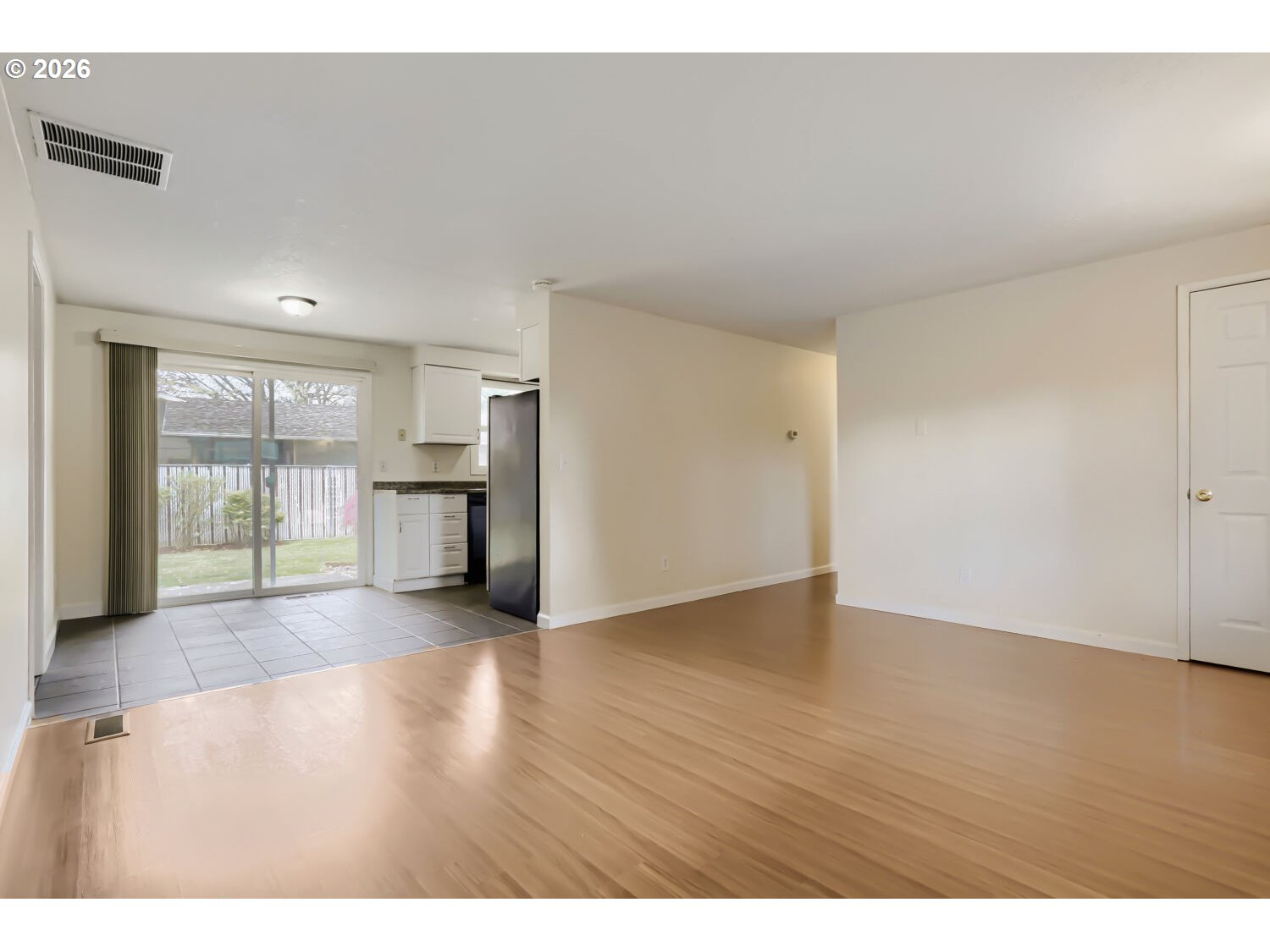 1675 Northeast Juniper Avenue Gresham, OR 97030 - Photo 7 of 29 a view of an empty room with window and wooden floor