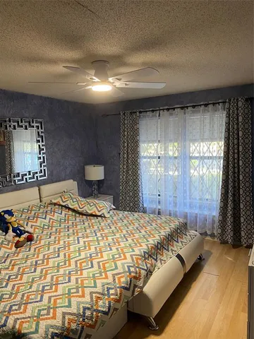 a bedroom with a bed and a large window