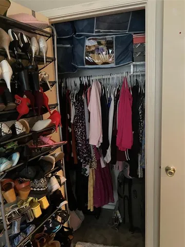 a view of walk in closet with clothes and shoes