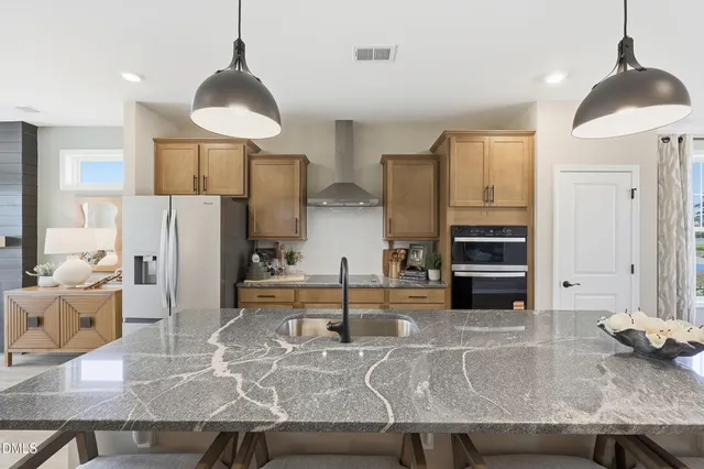 a kitchen with stainless steel appliances granite countertop a sink and a stove