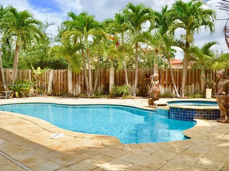 15601 Southwest 31st Lane Miami, FL 33185 - Photo 16 of 18 a view of swimming pool with a lawn chairs and wooden fence