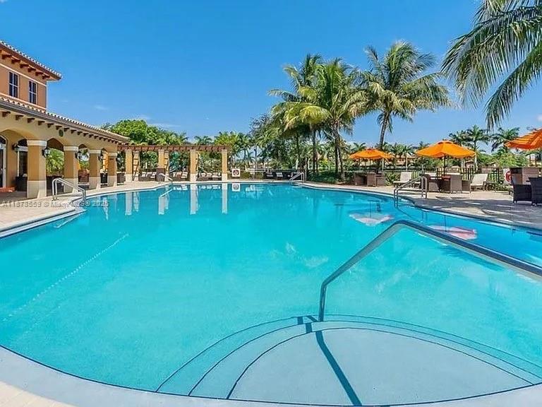 15601 Southwest 31st Lane Miami, FL 33185 - Photo 17 of 18 a view of a swimming pool with lawn chairs under an umbrella
