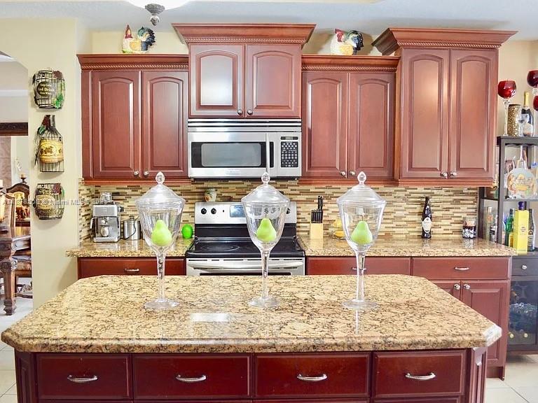 15601 Southwest 31st Lane Miami, FL 33185 - Photo 5 of 18 a kitchen with granite countertop a stove and cabinets