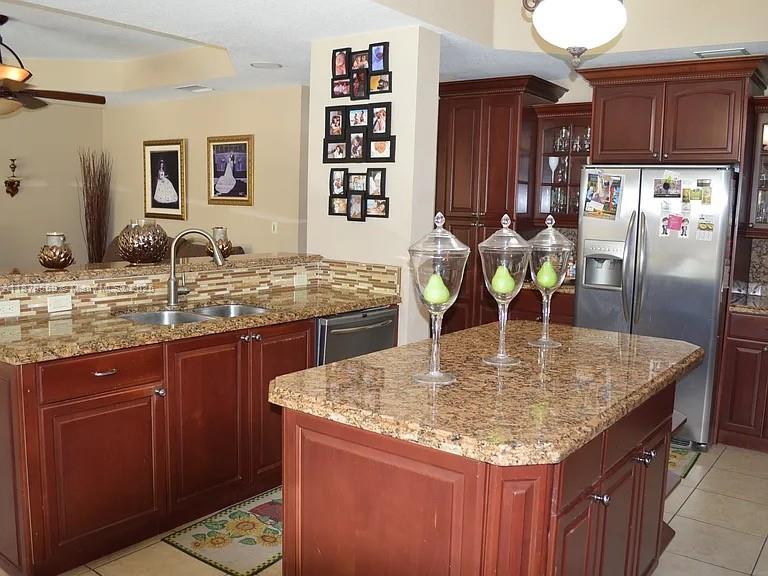 15601 Southwest 31st Lane Miami, FL 33185 - Photo 7 of 18 a kitchen with granite countertop a sink a counter space and cabinets