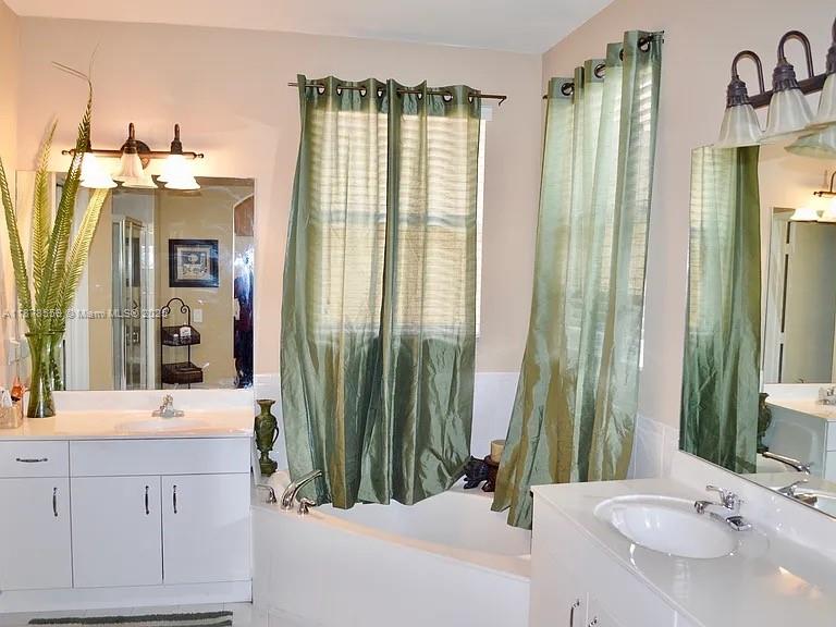 15601 Southwest 31st Lane Miami, FL 33185 - Photo 10 of 18 a bathroom with a double vanity sink and a mirror