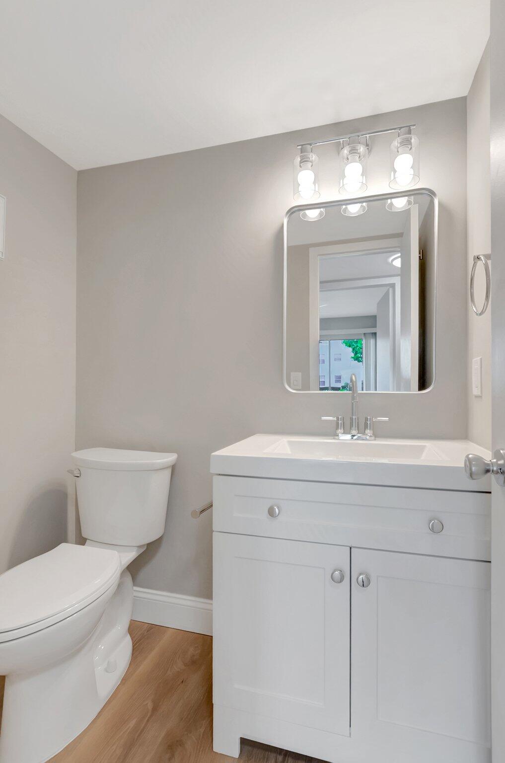 296 Fanshaw H Boca Raton, FL 33434 - Photo 15 of 59 a bathroom with a toilet a sink and mirror