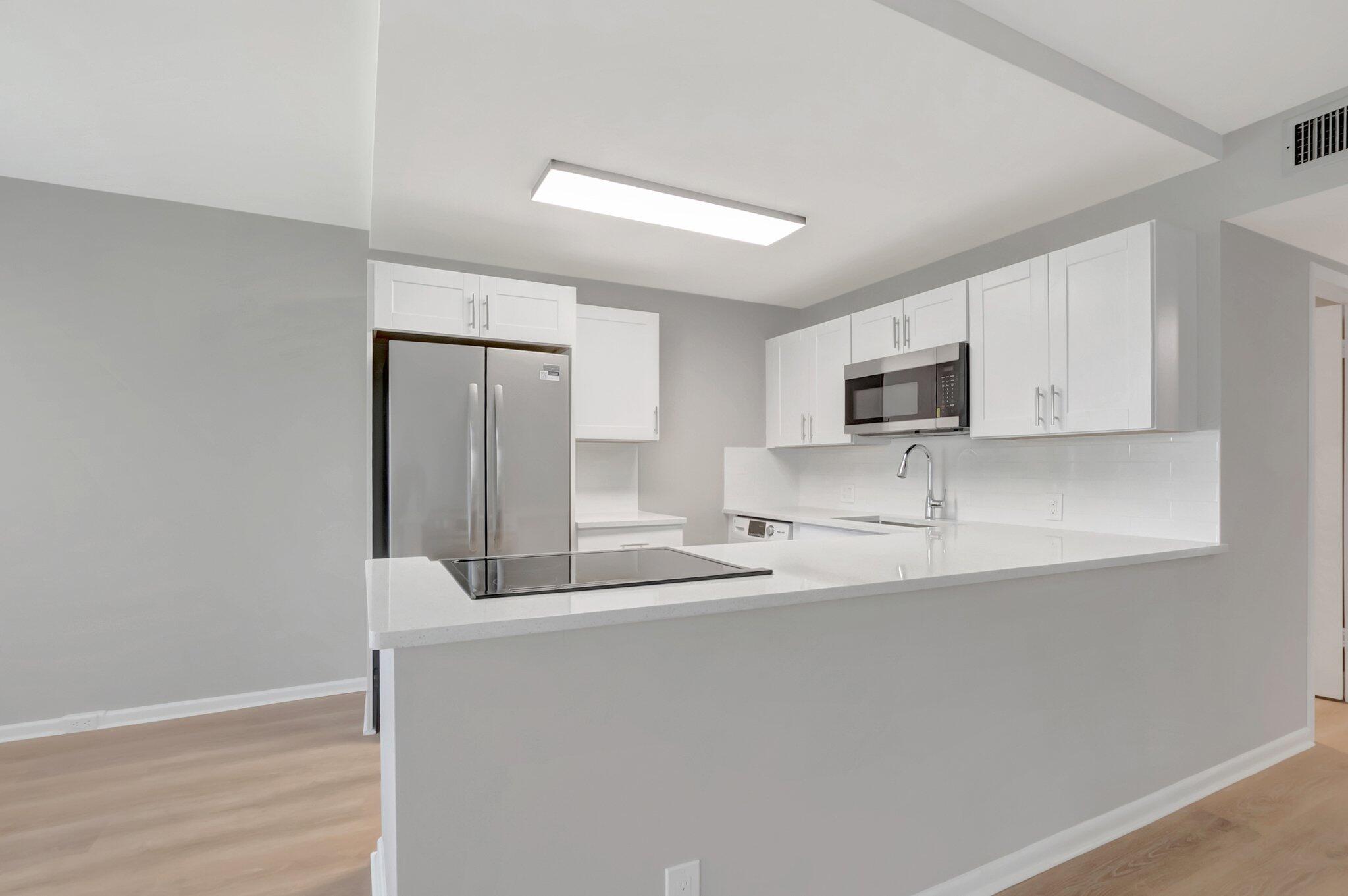 296 Fanshaw H Boca Raton, FL 33434 - Photo 4 of 59 a kitchen with stainless steel appliances granite countertop a microwave a sink and a refrigerator