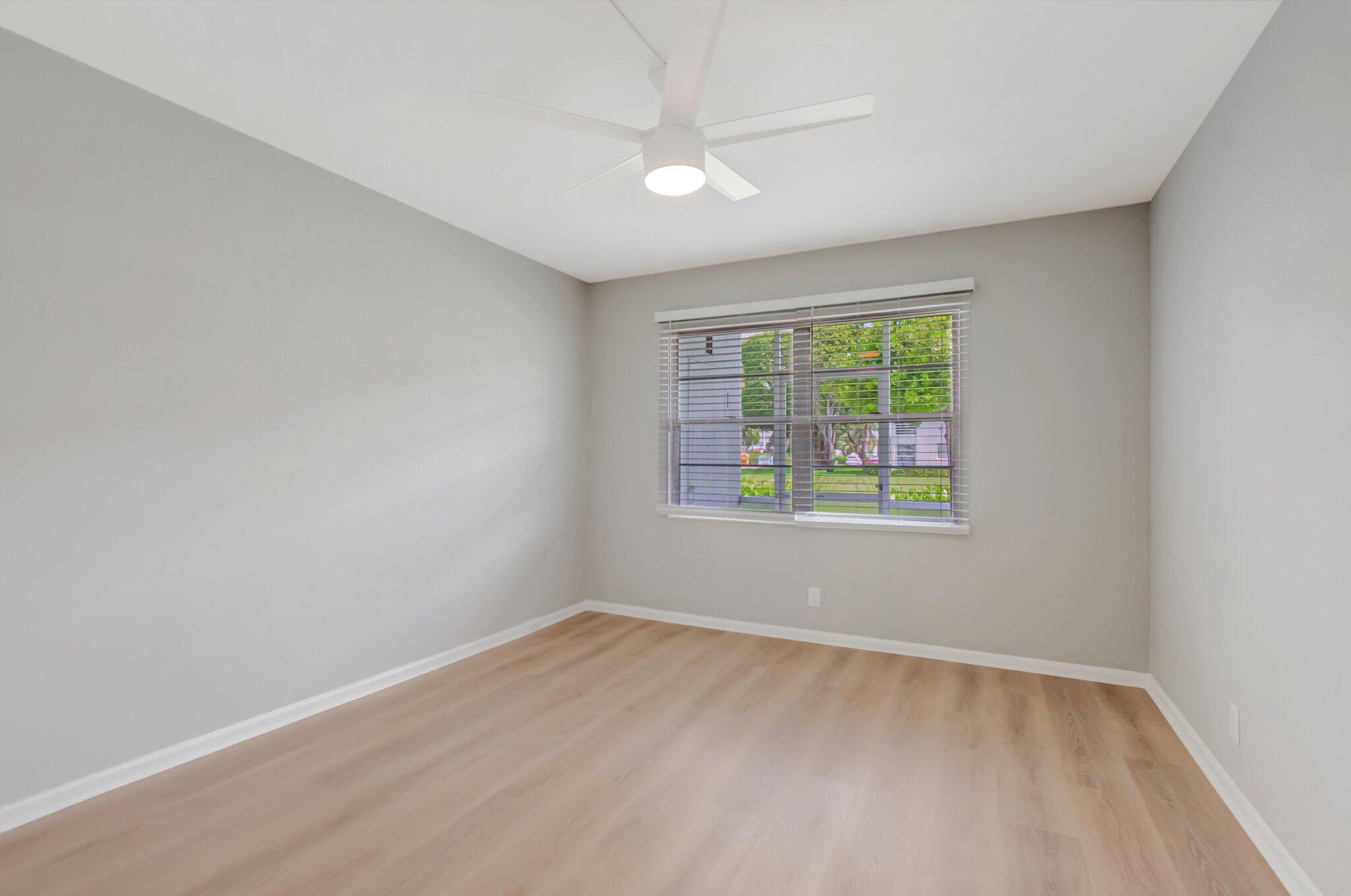 296 Fanshaw H Boca Raton, FL 33434 - Photo 6 of 59 wooden floor in an empty room with a window