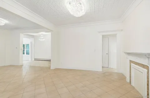 an empty room with a fireplace and a chandelier fan