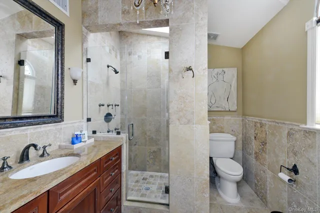 a bathroom with a granite countertop sink toilet and shower