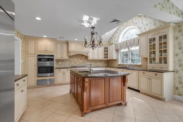 a kitchen with kitchen island granite countertop a sink counter top space appliances and cabinets