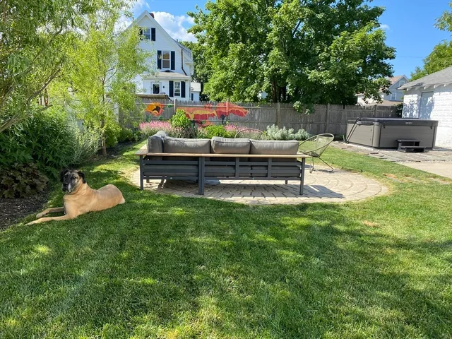 a view of a house with backyard and sitting area