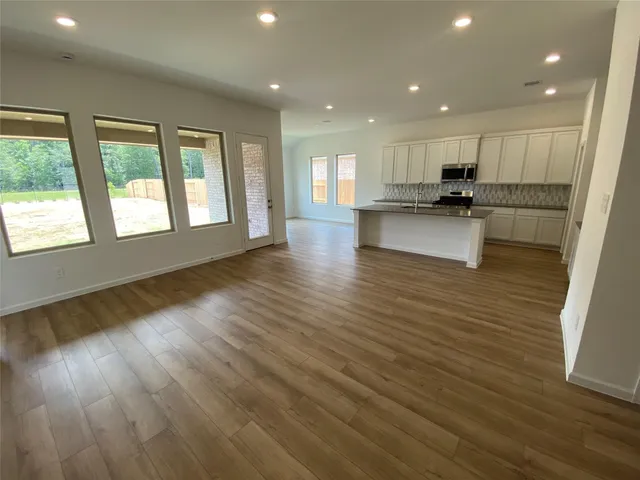a view of open kitchen with wooden floor and a sink