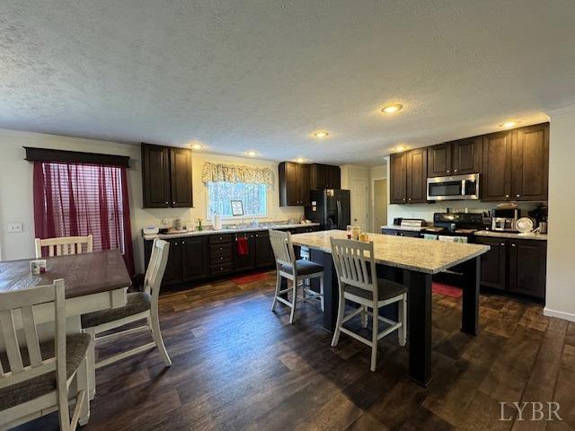 6098 Promise Land Road Appomattox, VA 24522 - Photo 13 of 35 a kitchen with stainless steel appliances kitchen island granite countertop a table chairs microwave and sink