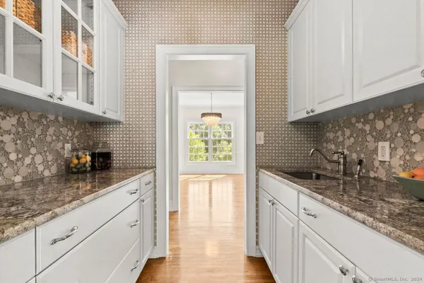 a kitchen with granite countertop white cabinets and white appliances