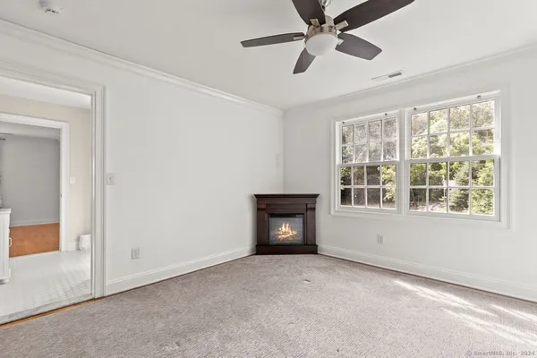 a view of an empty room with a window and a ceiling fan