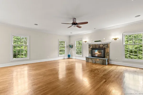a view of empty room with fireplace and wooden floor