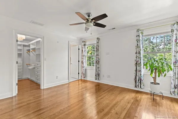 a view of an empty room with a window and wooden floor