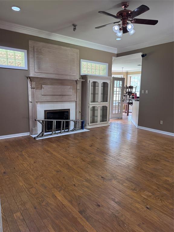 1704 South Bowen Road Pantego, TX 76013 - Photo 10 of 37 Hardwood flooring throughout this living area, featuring a decorative fireplace with a light wood mantel and hearth and ash built-in cabinets