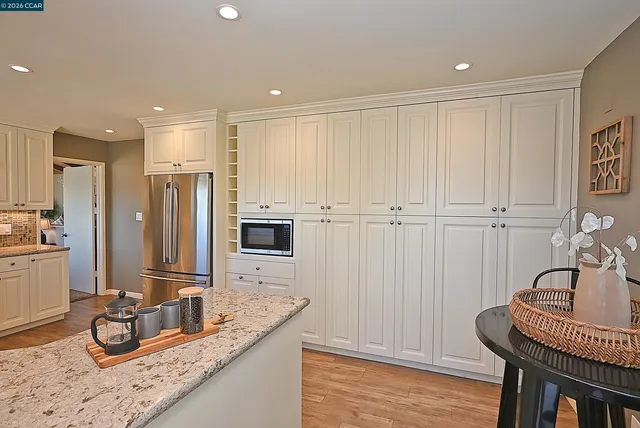 a kitchen with granite countertop stainless steel appliances and wooden floor