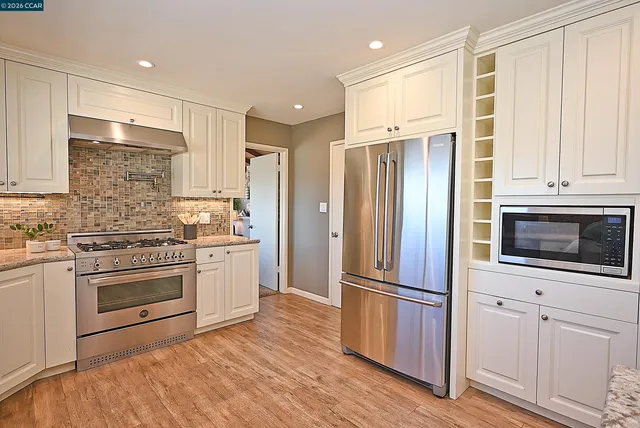 a bedroom with a bed and a dresser next to a window