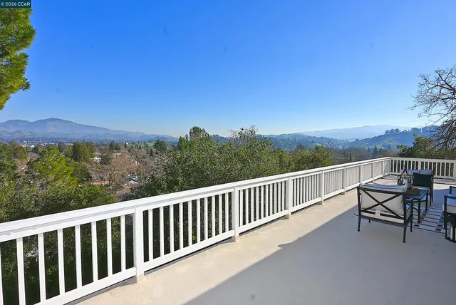 a balcony with wooden floor and city view