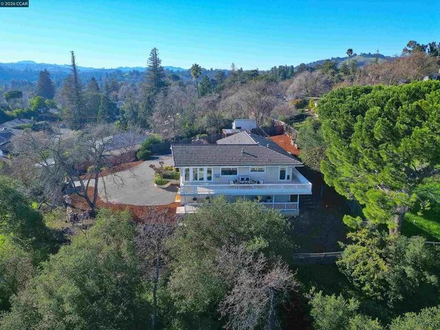 an aerial view of a house with yard and swimming pool