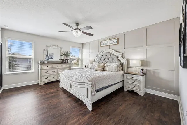 a bedroom with a bed and a dresser with wooden floor