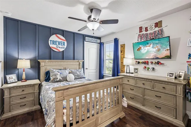 a bedroom with a bed and a flat tv screen on dresser
