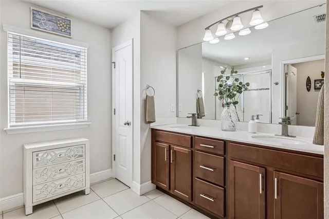 a bathroom with a double vanity sink a large mirror and a shower