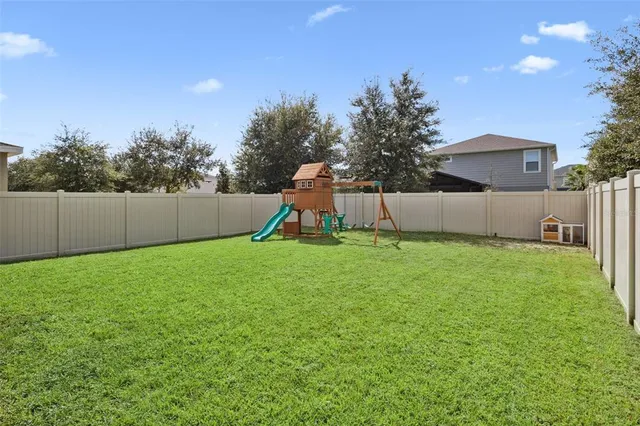 a view of a house with a yard and palm trees